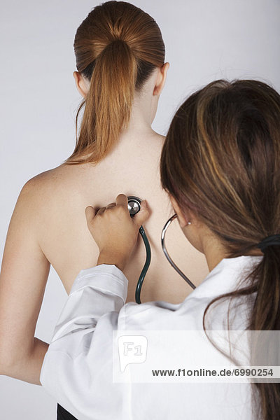 Doctor Listening to Womans Back with Stethoscope