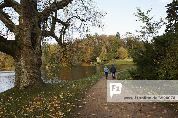 Couple Walking on Path by Pond  Stourhead  Wiltshire  England