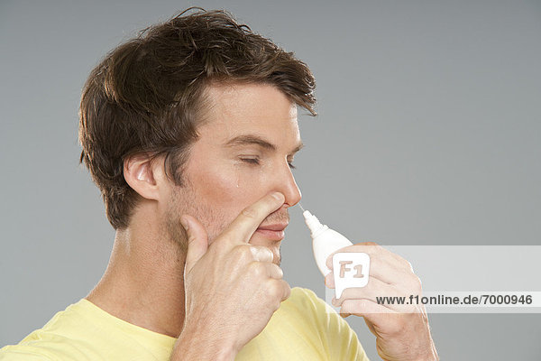 Mann mit Nasenspray
