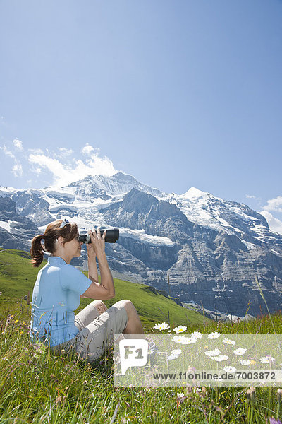sitzend  benutzen  Frau  Berg  Fernglas  Seitenansicht  Berner Oberland  Schweiz