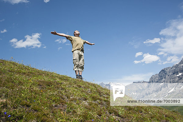 stehend  Berg  Mann  Arme ausbreiten  Arme ausstrecken  Seitenansicht  strecken  Berner Oberland  Schweiz