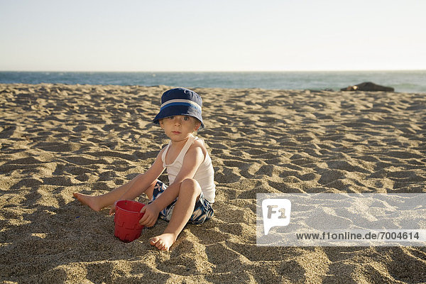 Portrait of Boy Digging in Sand on Beach