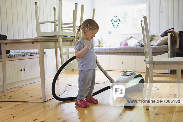 Young Girl Vacuuming Hardwood Floor  Sweden