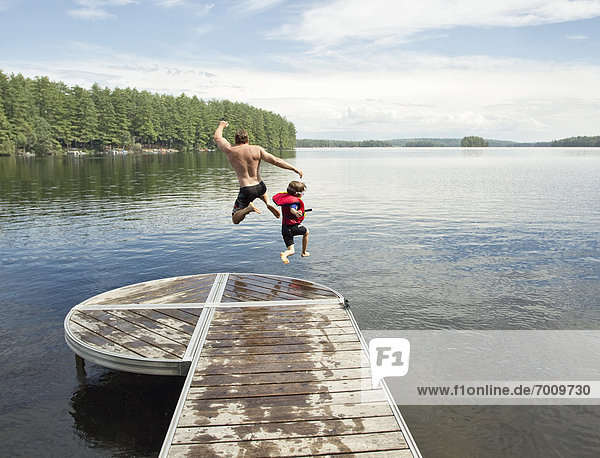 Father and Son Jumping in Lake  Belgrade Lakes  Maine  USA