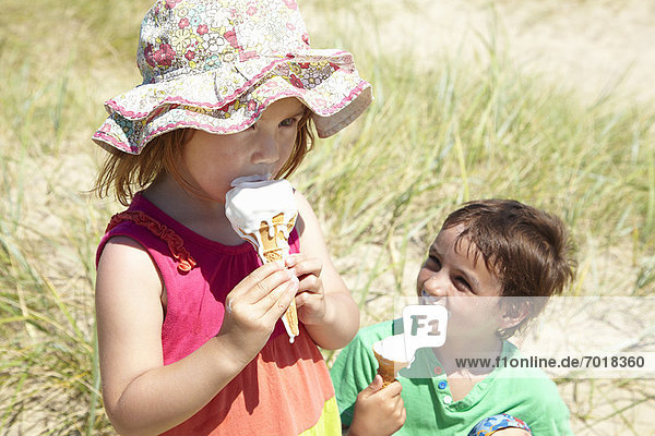 Kinder essen Eis am Strand