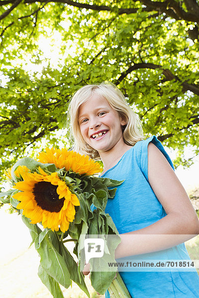 Lächelndes Mädchen mit Sonnenblumen