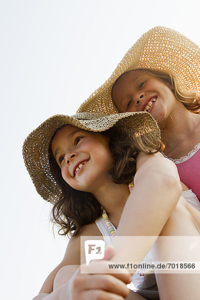 Smiling girls wearing sunhats outdoors
