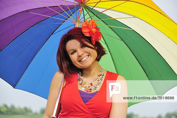 Frau mit farbenfrohem Regenschirm