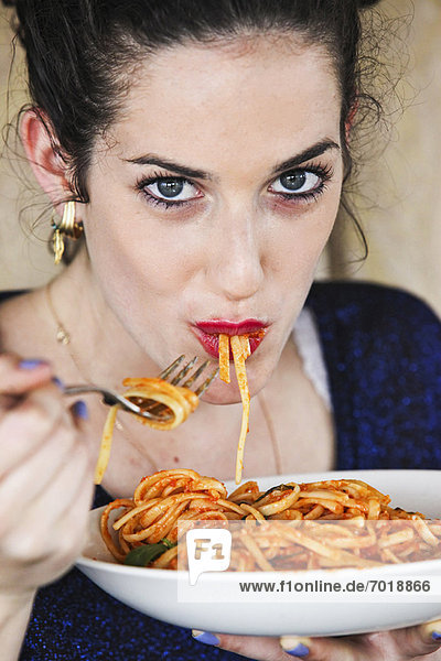 Woman eating plate of pasta