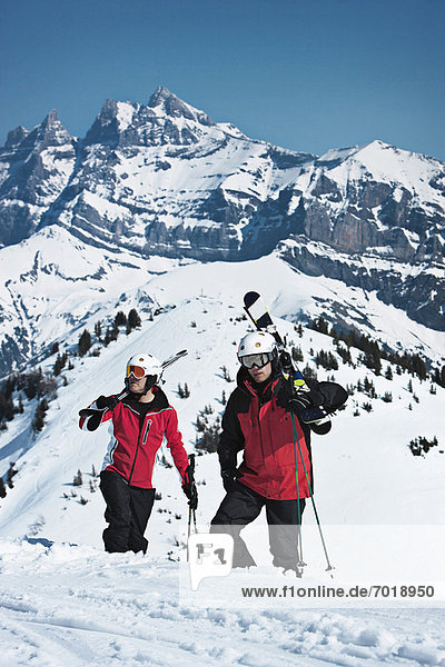 Skiers climbing snowy mountainside