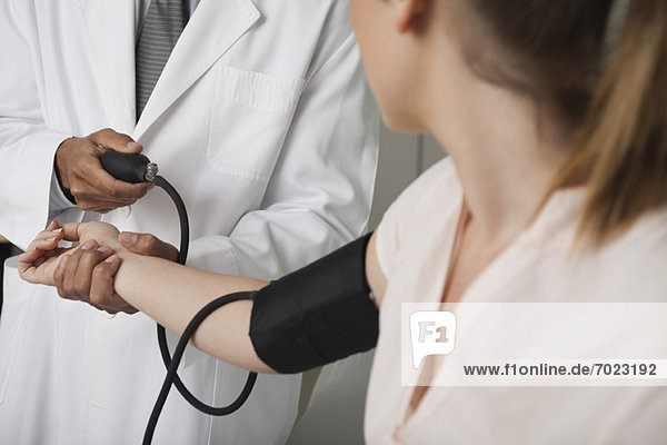 Doctor checking patient's blood pressure  cropped