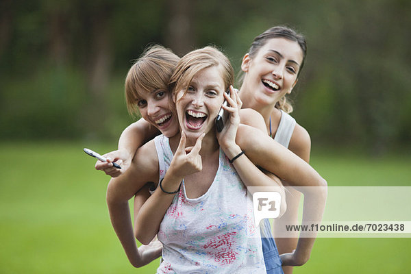 Junge Frauen zusammen im Freien  lächelnd