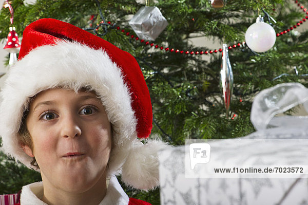 Junge mit Nikolausmütze macht überraschtes Gesicht  Porträt