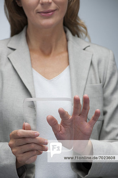 Geschäftsfrau mit transparentem digitalem Tablett