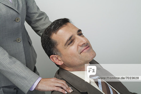 Mature businessman having shoulders massaged