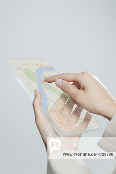 Frau mit transparentem digitalem Tablett mit Touchscreen zur Kartenansicht  beschnitten