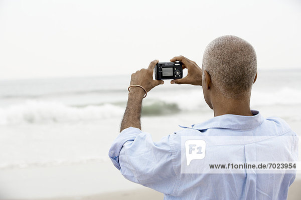 Mann  Strand  fotografieren  Rückansicht  Ansicht