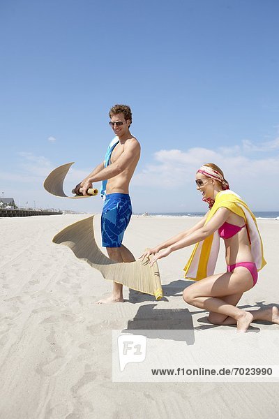 Young couple spreading beach mats on beach  Spring Lake  New Jersey  USA