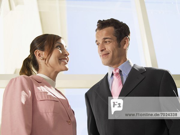 Businesswoman and businessman looking each other (low angle view)