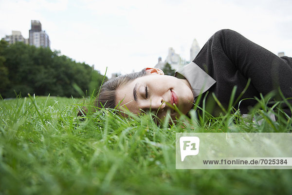 Young woman sleeping on grass (low angle view)