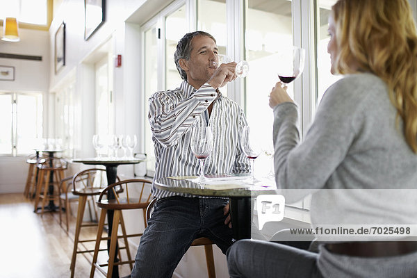 Woman and man tasting red wine