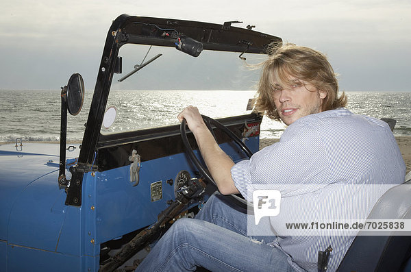 Young man driving beach buggy