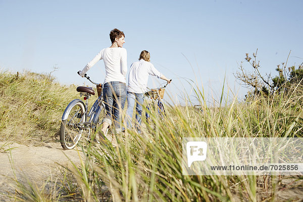 Couple with bicycles walking on path