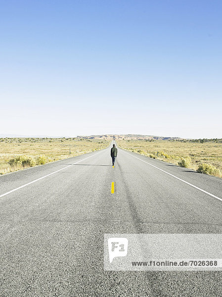 Man walking on centerline of rural road