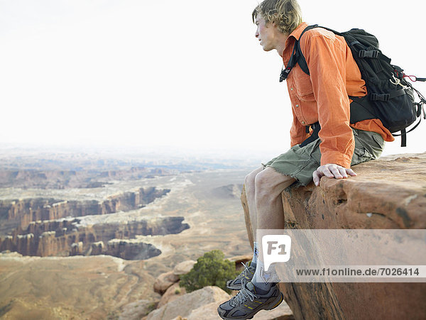 Male hiker sitting on cliff