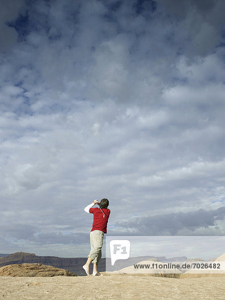 Man playing golf at rock strata