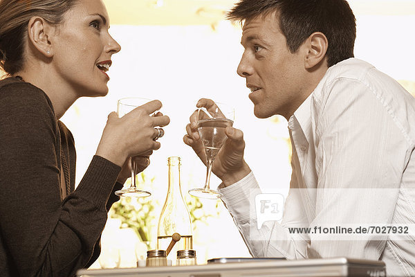 Mid adult couple drinking water in restaurant (low angle view)