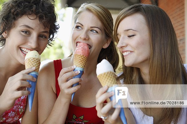 Three teenage girls eating ice creams