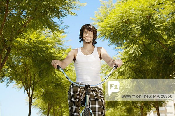 Young man cycling (low angle view)