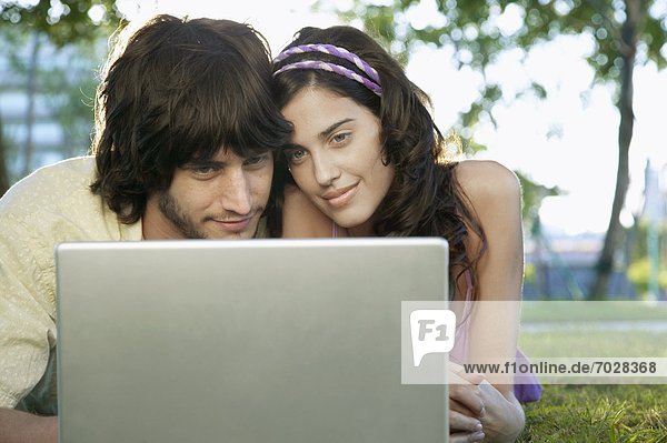 Junges Paar benutzt einen Laptop