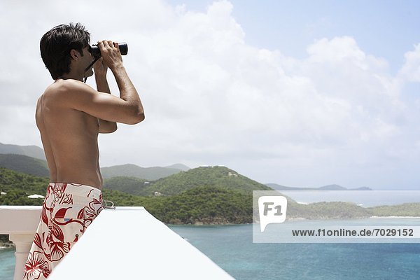 Young man using binoculars at seaside  St. John  US Virgin Islands  USA