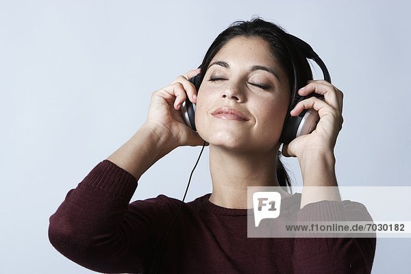 Young woman listening to headphones with eyes closed