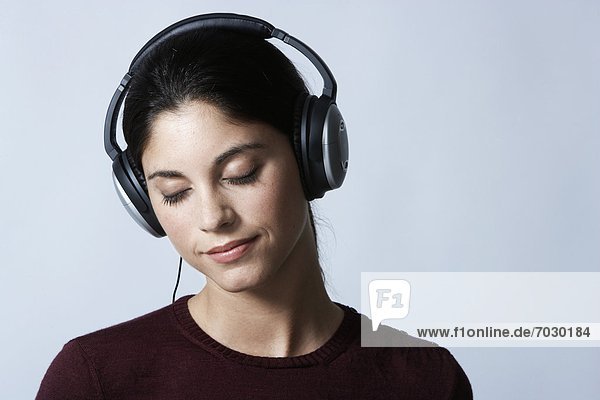 Young woman listening to headphones with eyes closed