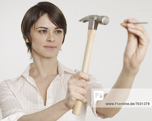 Young Woman Holding Hammer and Nail