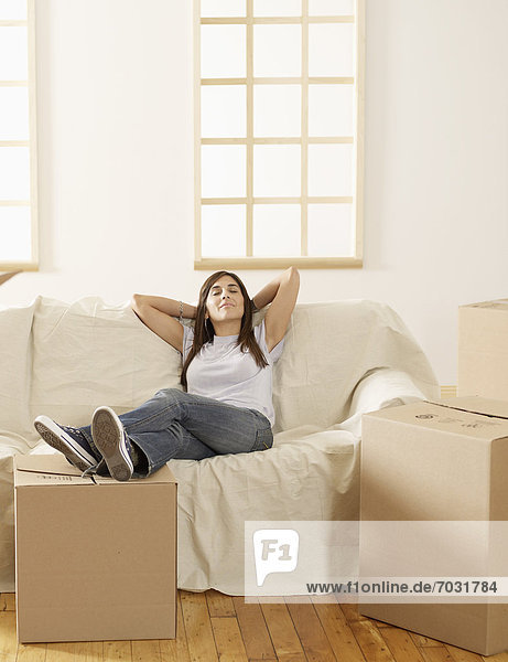 Mid-Adult Woman Resting by Cardboard Boxes