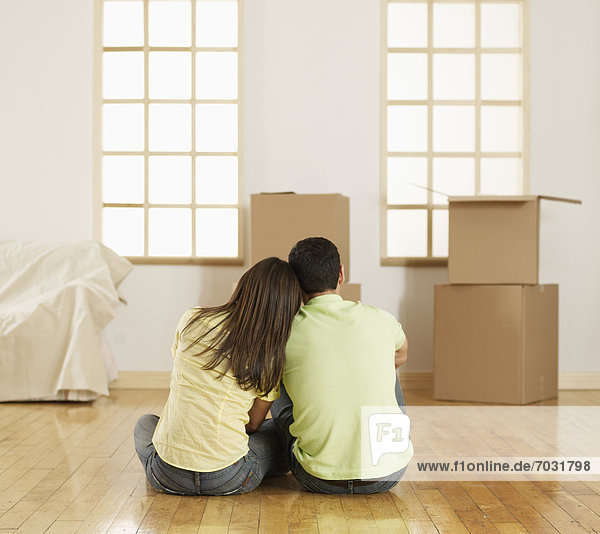 Mid-Adult Couple Sitting on Floor near Cardboard Boxes