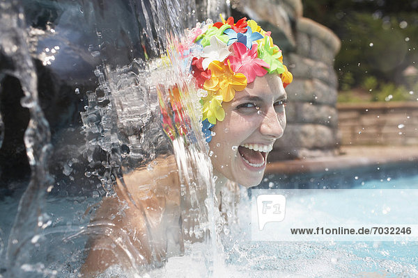 Mid-Adult Woman in Swimcap Laughing Under Waterfall