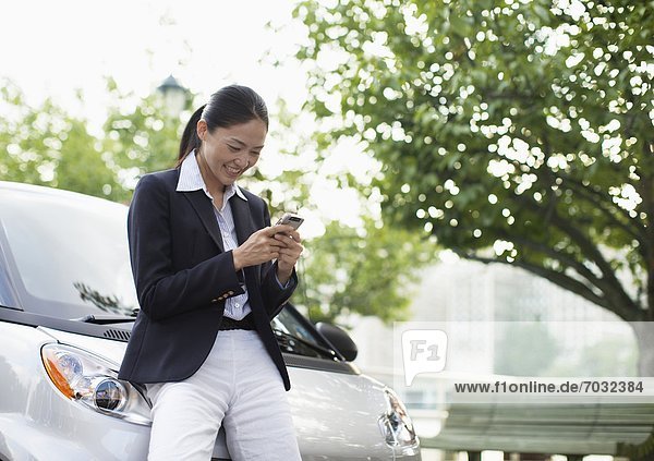 Mid-Adult Woman Text Messaging by Smart Car