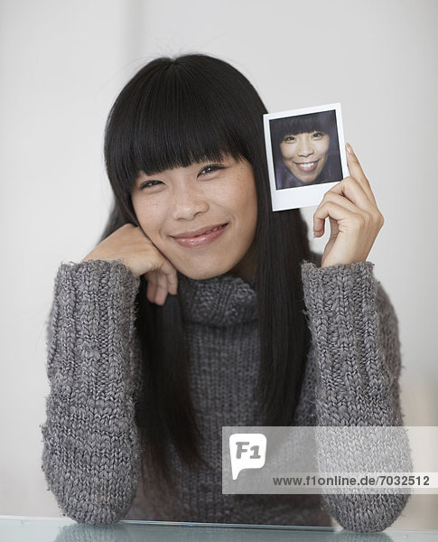 Mid-Adult Frau Holding Foto von sich selbst