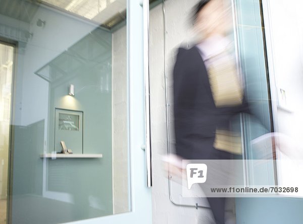 Businesswoman Walking Through Doors