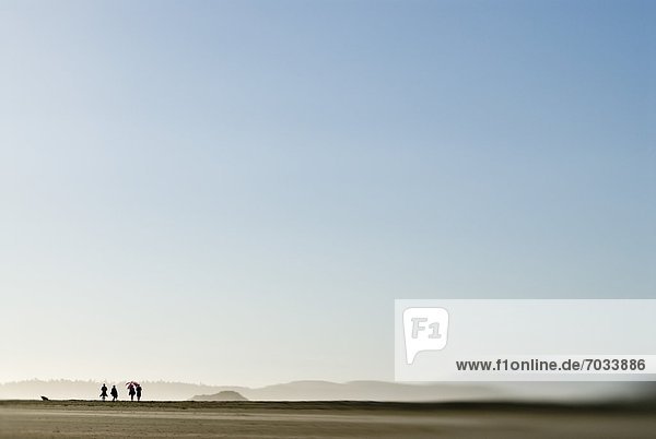 People In The Distance On Beach Under Blue Sky