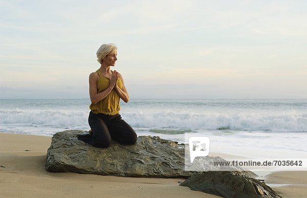 Mature Woman In Yoga Position On Shoreline