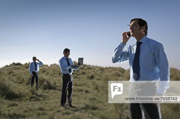 Businessmen In Field With Their Communications Technology