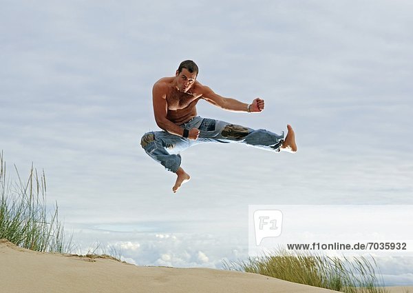 Mann nehmen Strand Kunst Kampfsportler Pose