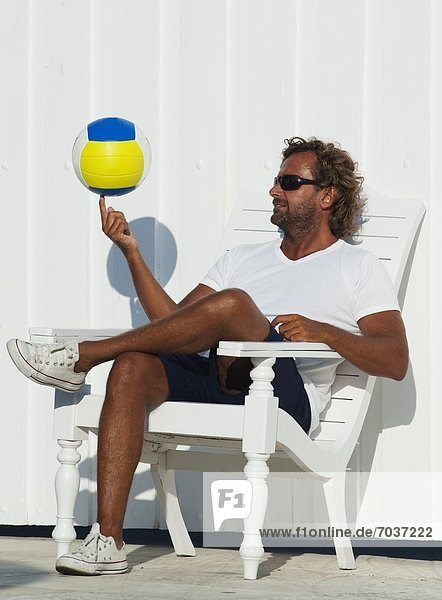 sitzend  Mann  Stuhl  balancieren  Terrasse  Ball Spielzeug