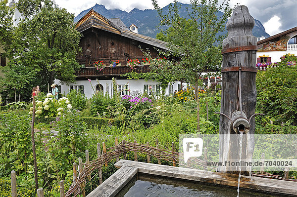 Europa Wohnhaus Garten Ziehbrunnen Brunnen Garmisch Partenkirchen Bayern Deutschland